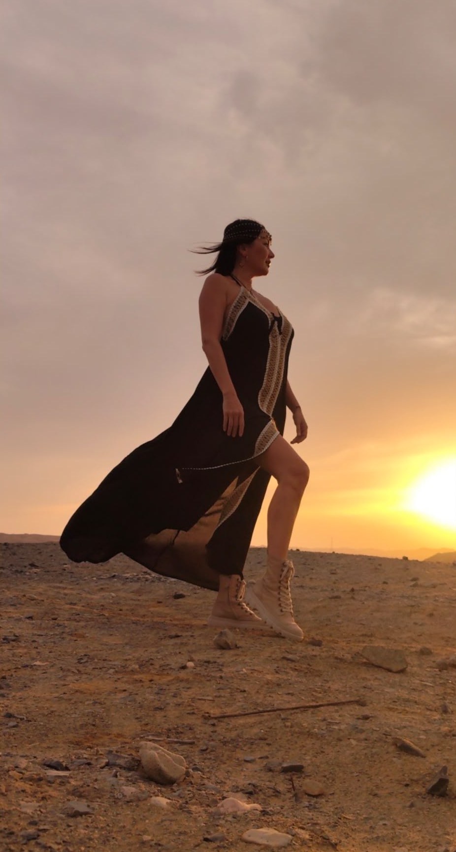 A flowing black dress catching the breeze at sunset in the desert